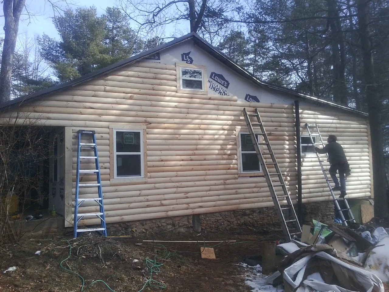 Ladders set against fresh log siding during an exterior remodel in Basalt