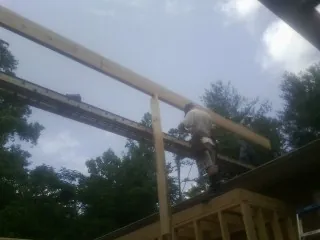 Carpenter setting a ridge beam over a new addition frame — Ice Dam Removal by Roofing Brothers in Basalt
