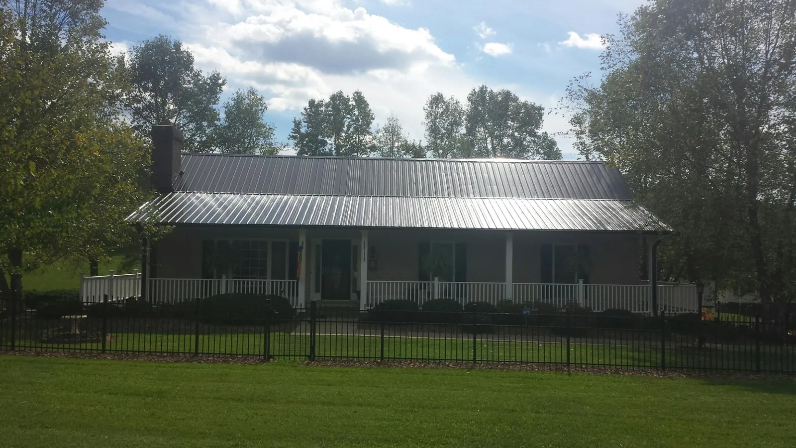 Gray metal roof on a brick ranch with a full width front porch — Gutter Guard Installation work by our crew in Basalt