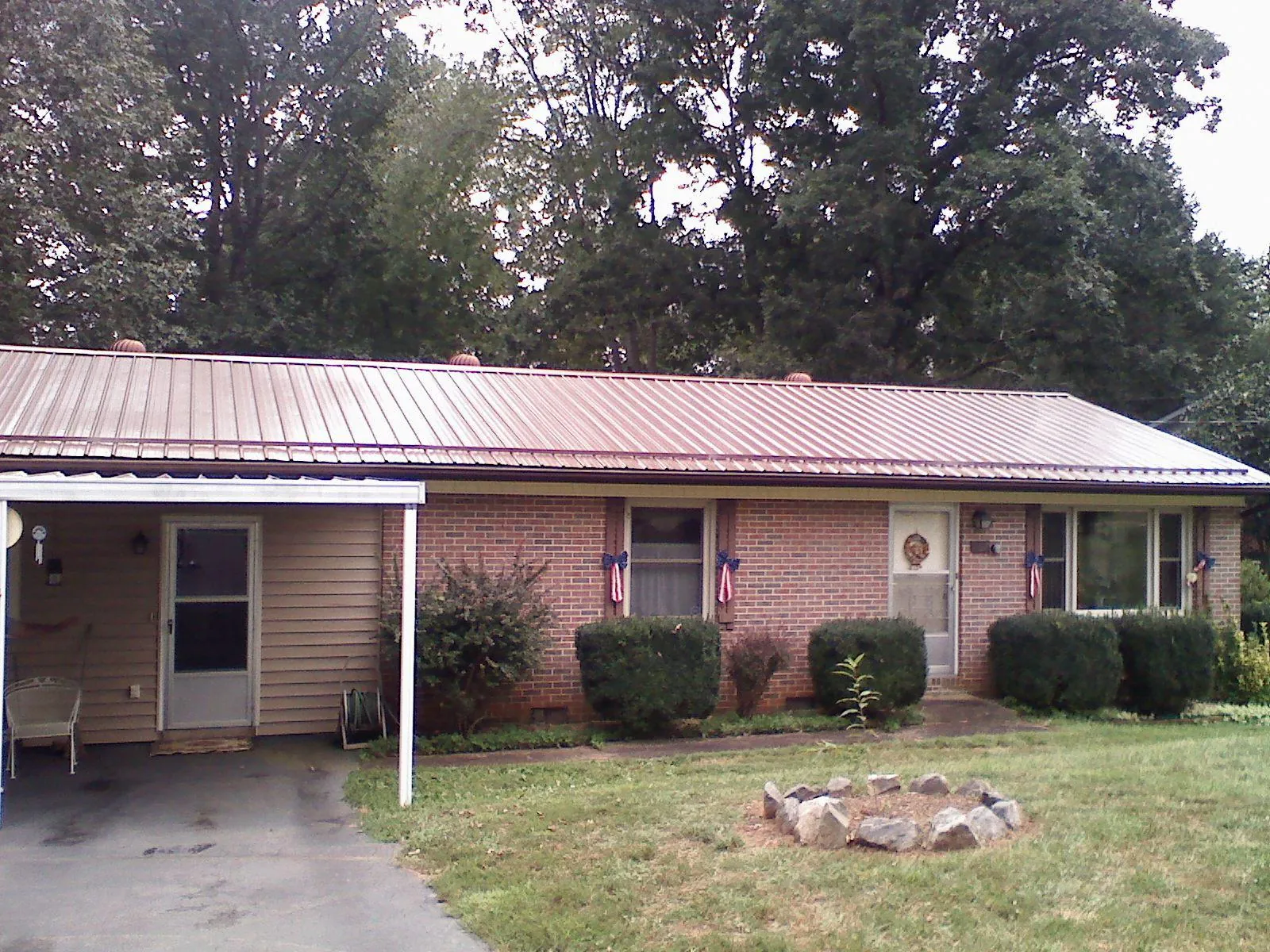 Bronze metal roof and carport on a brick ranch home — Roof Repair work by our crew in Basalt